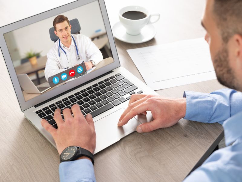 Un consulente di sulla sicurezza sul lavoro, mentre sta comunicando con un medico in una chiamata video